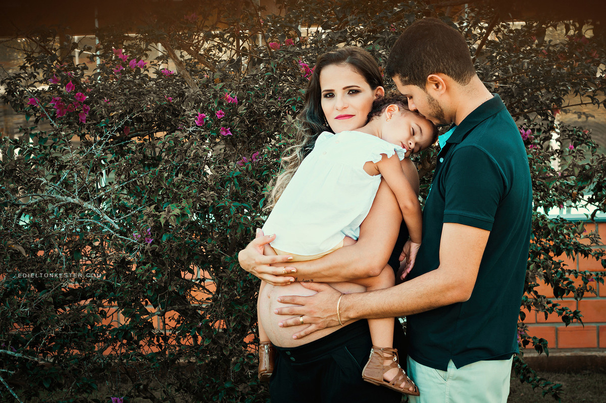 familia em ensaio de gestante com a filha dormindo no colo da mae