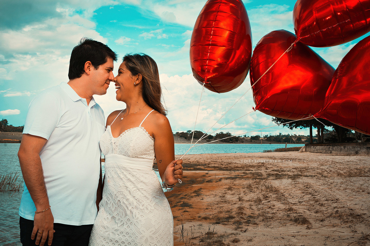 ensaio de pre casamento com baloes de coração na praia com noiva sorrindo