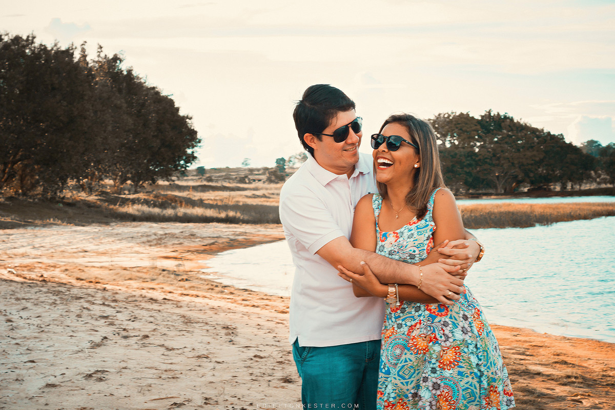 noivos abraçados e caminhando na praia sorrindo apaixonados