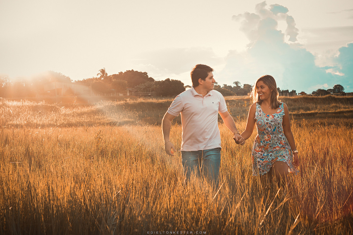 noivos correndo de maos dadas com por do sol