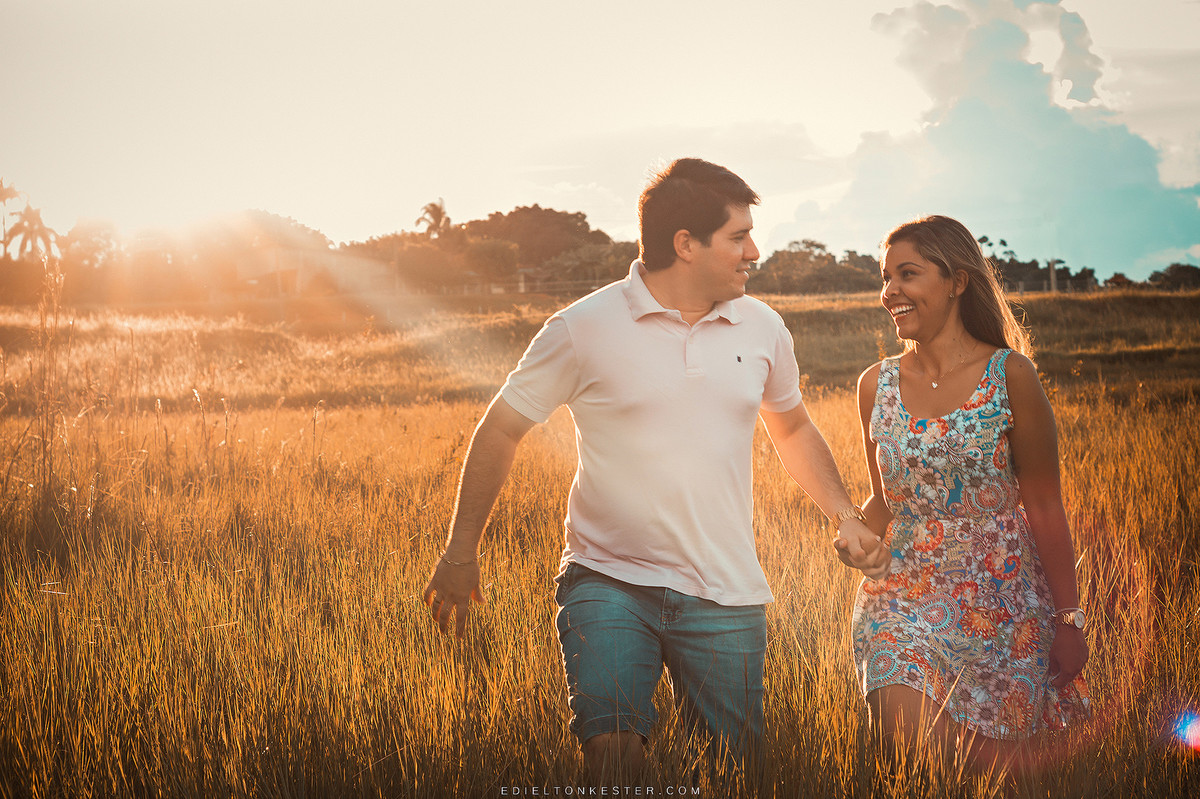 noivos correndo de maos dadas com por do sol