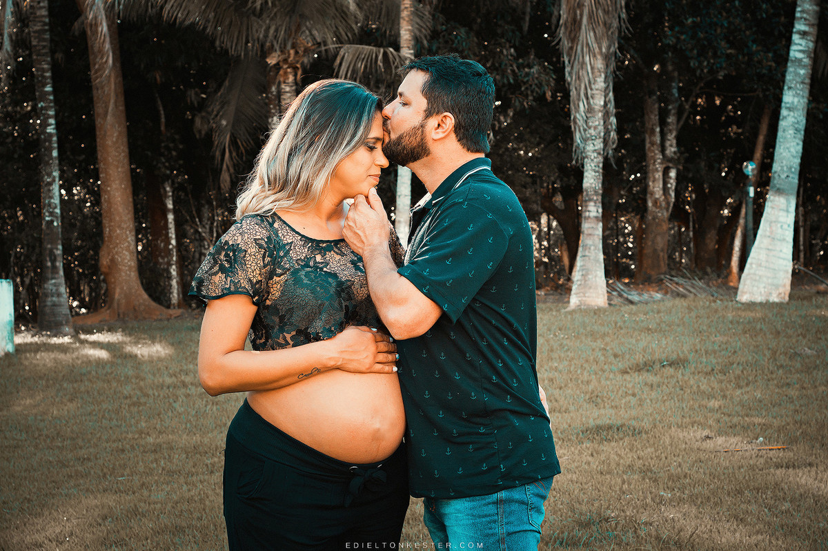 ensaio de gestante com pai beijando a testa da esposa