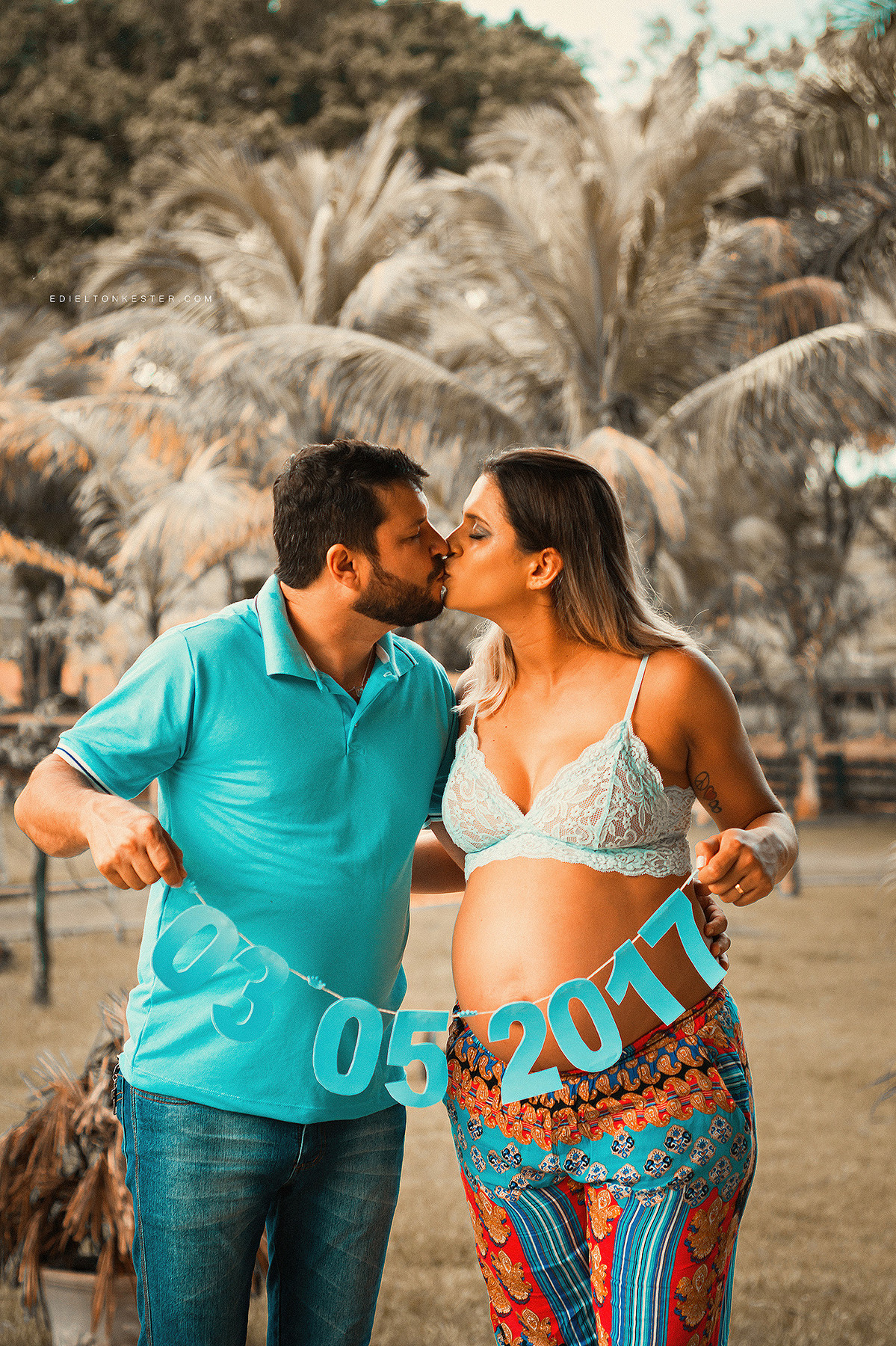 gestante em ensaio fotografico  beijando seu esposo