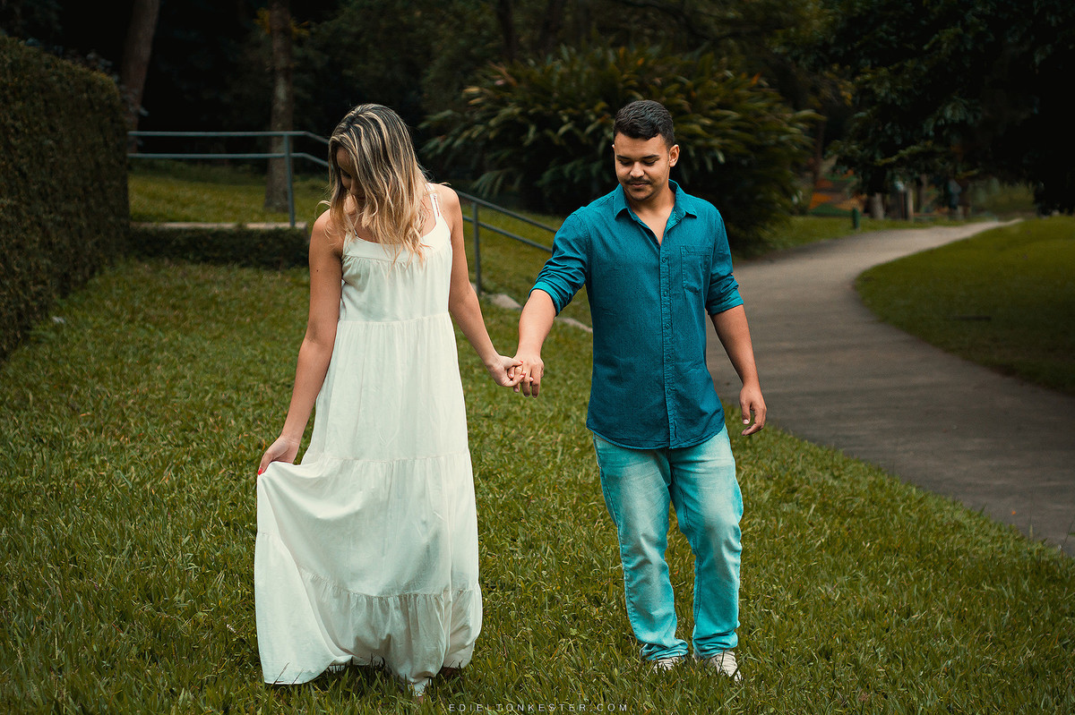 noivos caminhando de maos dadas e noiva segurando seu vestido