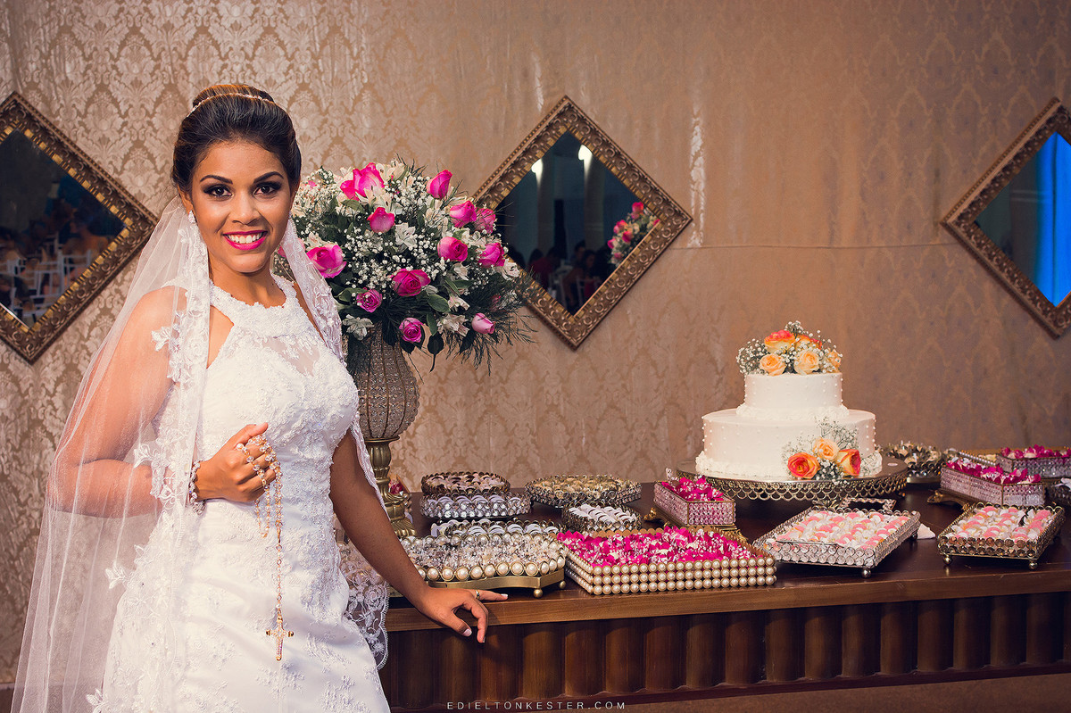 noiva em frente a mesa do bolo com decoração linda