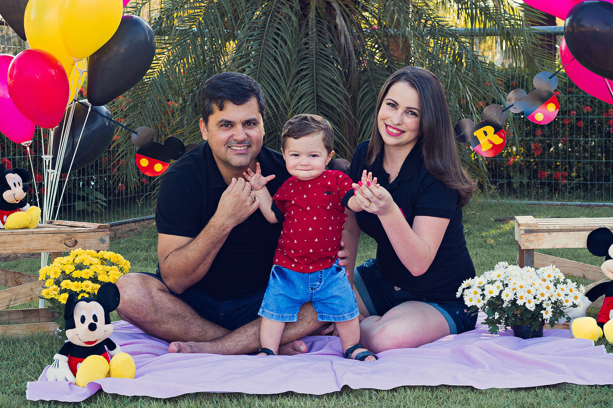 ensaio de 1 ano com garotinho sorrindo com seus pais em ensaio famillia