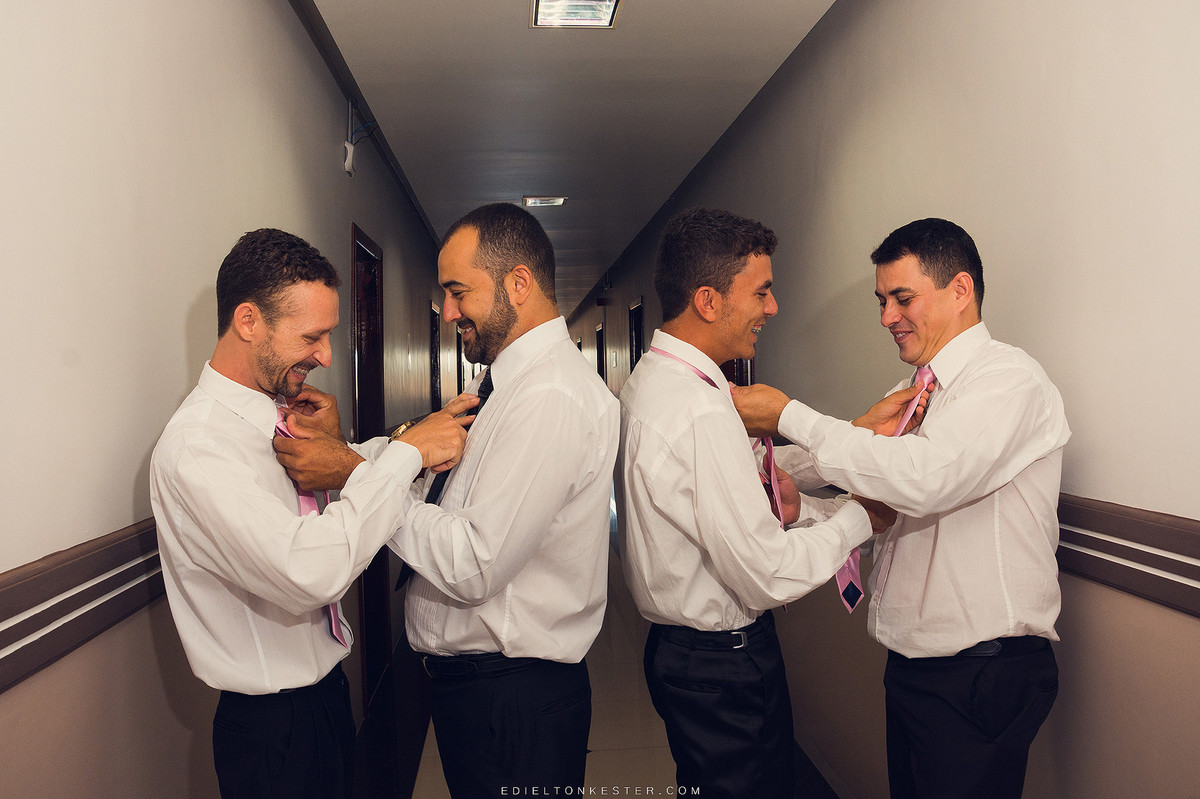 noivo e padrinhos arrumando gravata para casamento