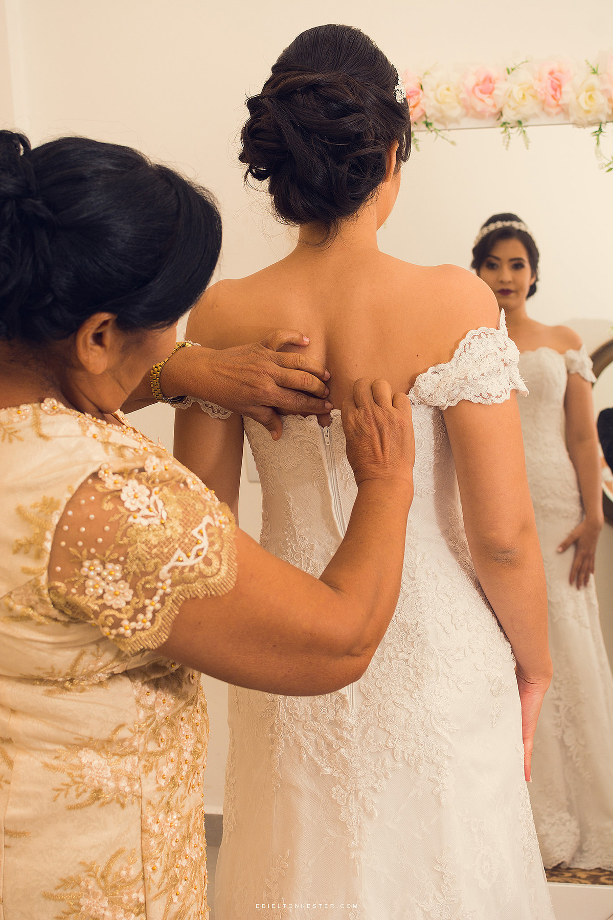 mae da noiva fechando o vestido da filha