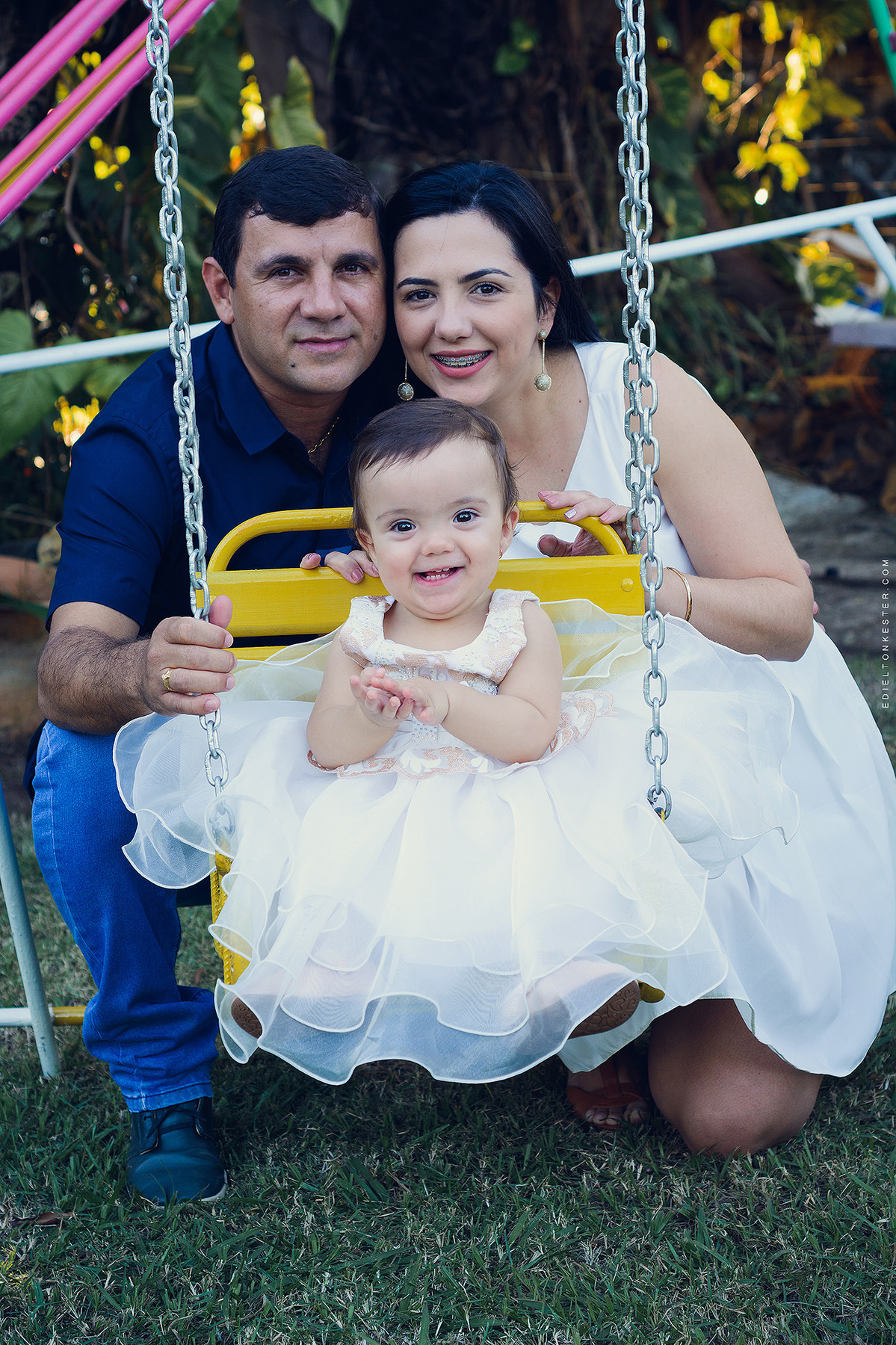 pais e filha sorrindo no balanço em aniversario da laiza 1 aninho pelo fotografo de casamentos e familias edielton kester
