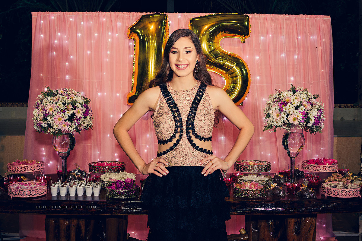 menina de 15 anos na mesa do bolo posando para fotos