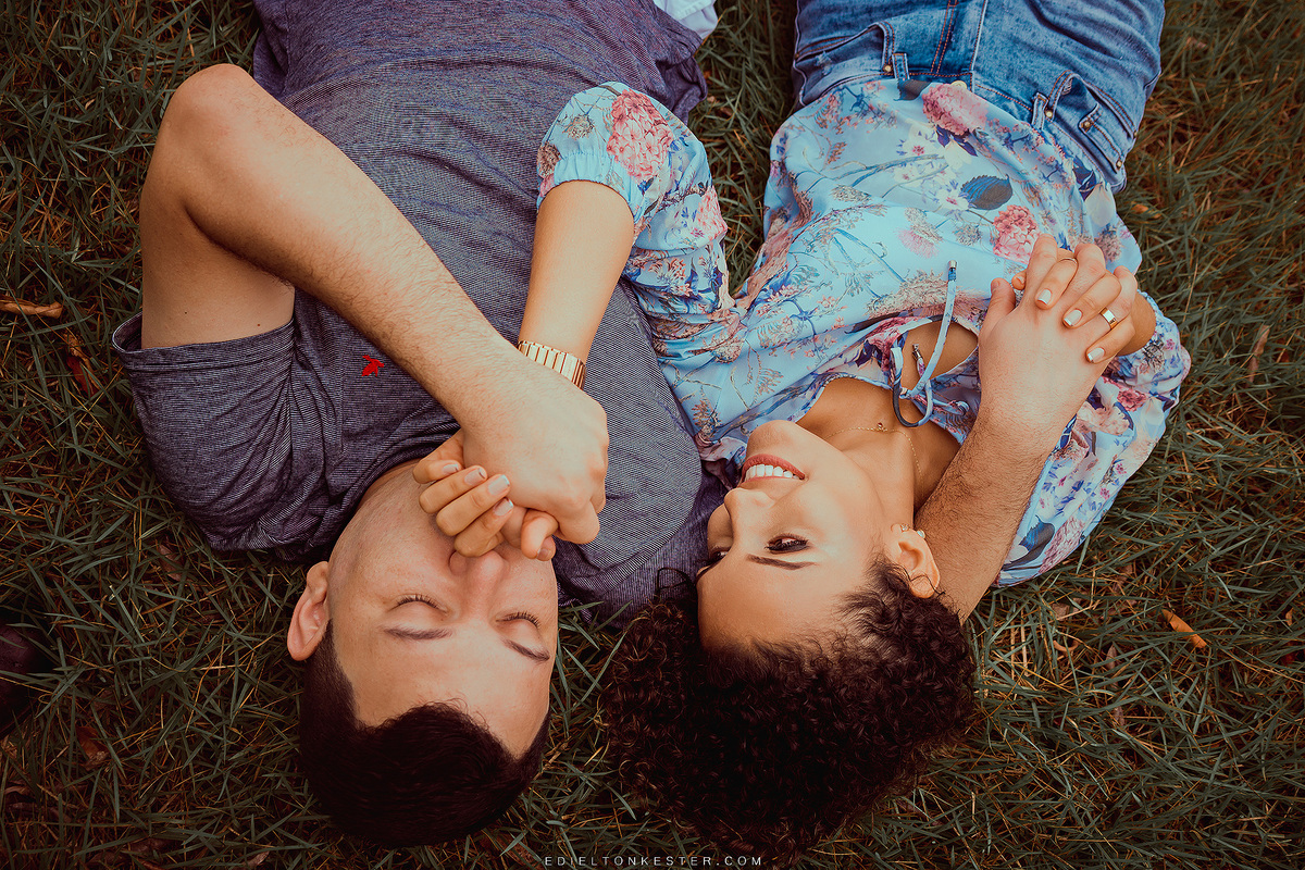 noivo beijando a mao da noiva deitados