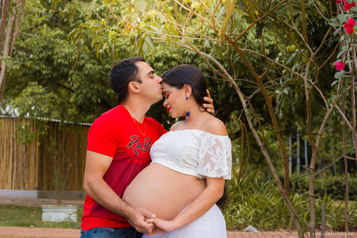 esposo beijando a testa da mulher em ensaio da gestação
