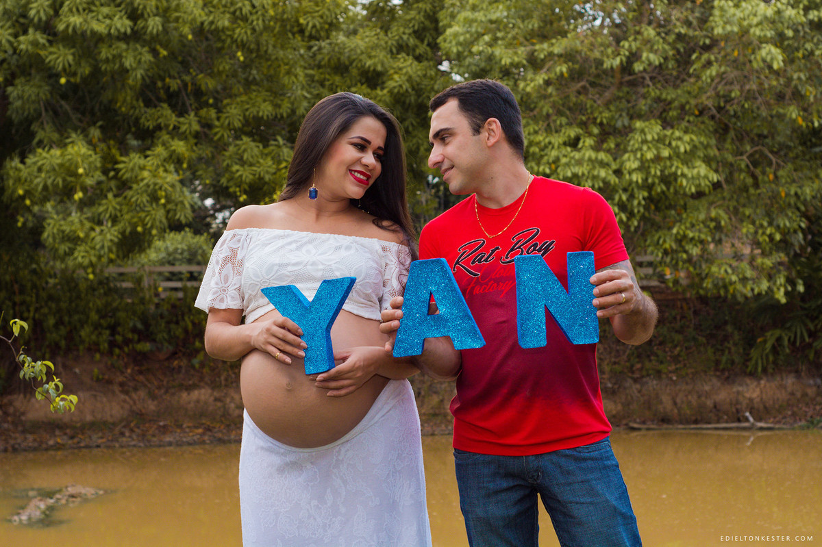 pais segurando o nome do filho em letras de eva em ensaio de gravidez