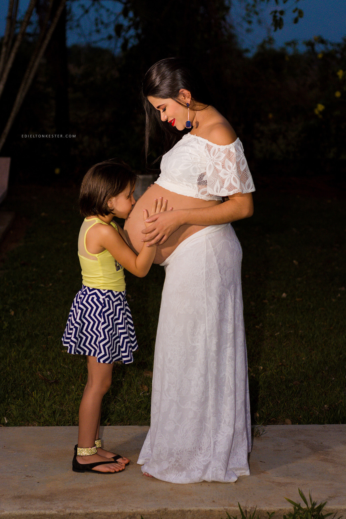 criança beijando a barriga da gravida