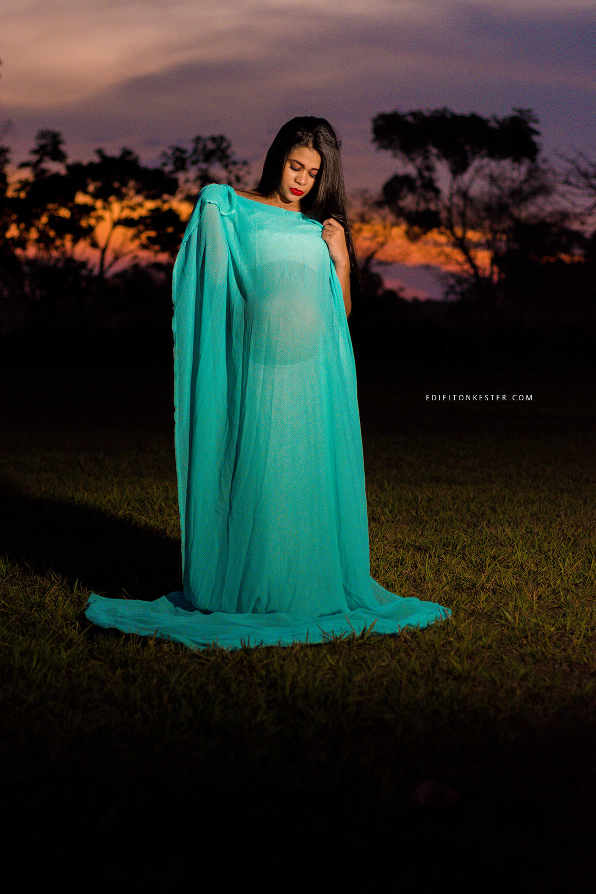 foto de gravida usando tecido no por do sol