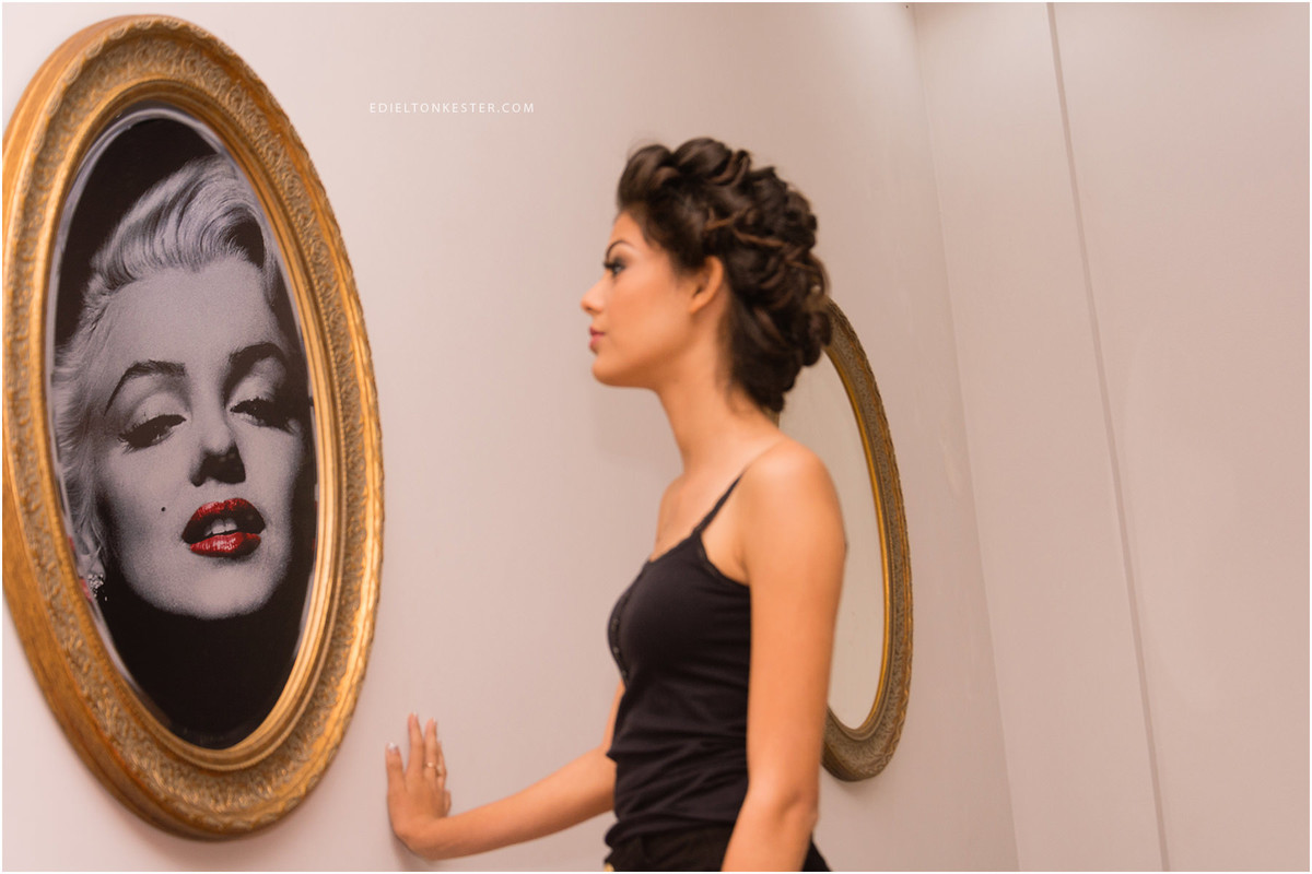 moça de 15 anos se olhando no espelho no salão e vendo reflexo da marilyn monroe