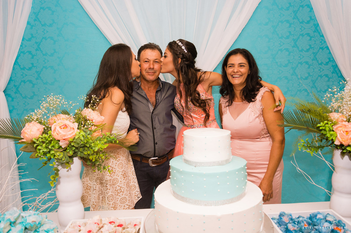filhas beijando o pai em aniversário de 15 anos enquanto a mae sorri