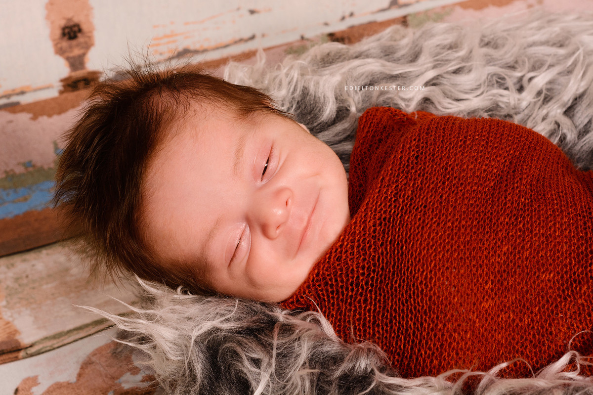 bebe sorrindo em ensaio newborn enrolado em wrap