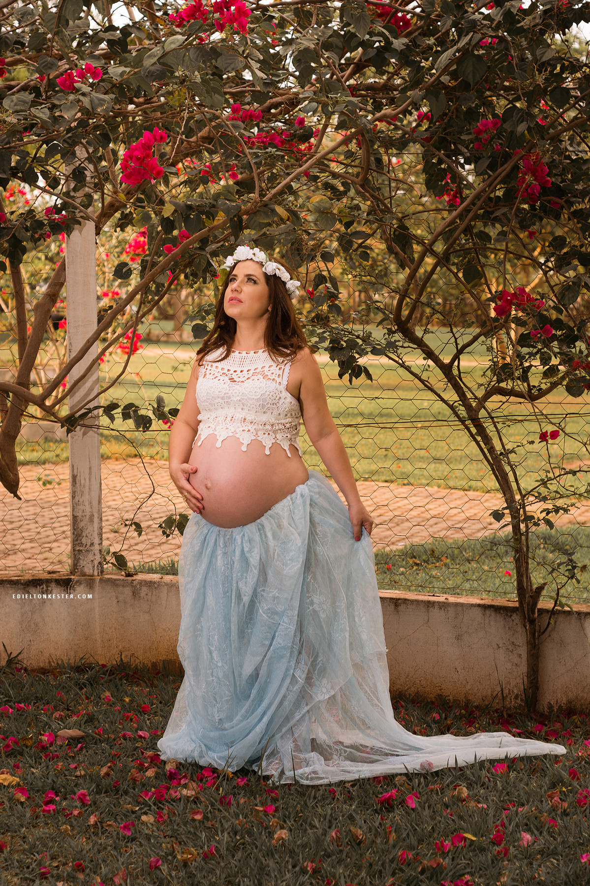gestante com saia de tule perto de flores em ensaio externo