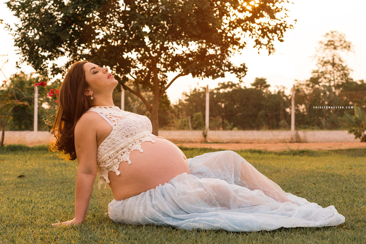 gravida sentada em ensaio externo e com olhos fechados
