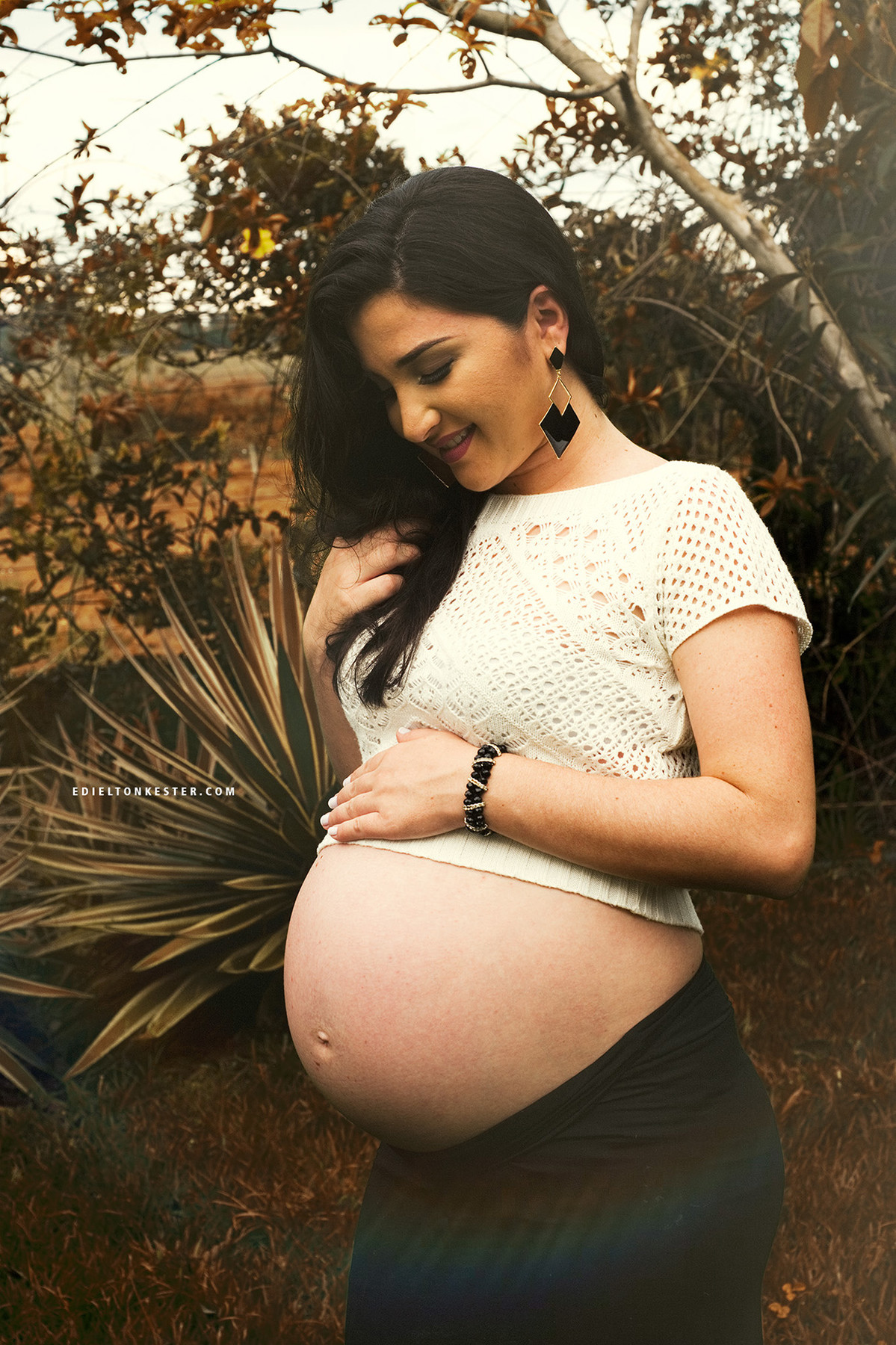 fotos de gravidas em ensaio externo com gestante olhando para barriga