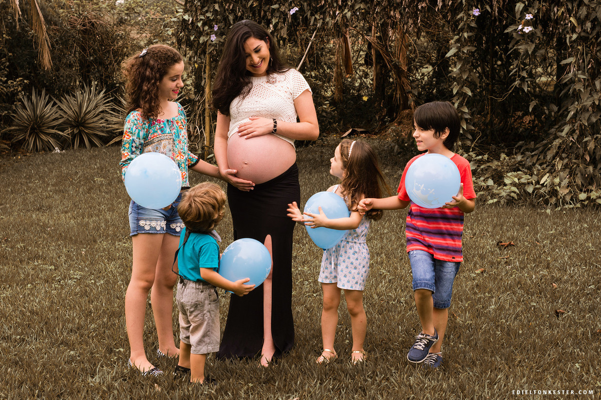 sobrinhos em volta da tia gravida com a mao na barriga