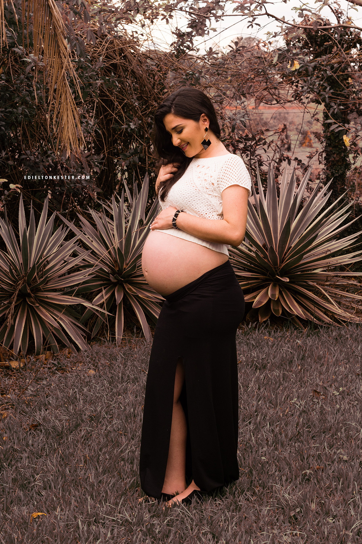 gravida com a mao no cabelo e olhando para a barriga