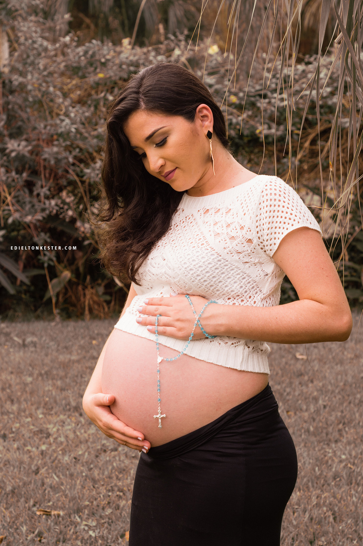 gravida com terço na barriga em momento de fé