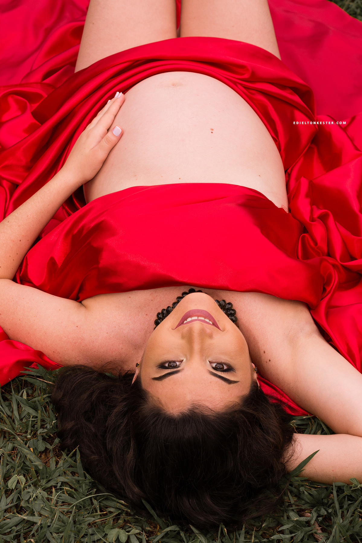 gravida deitada com tecido vermelho