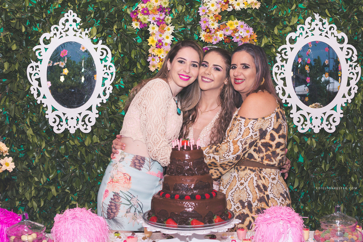 aniversariante de 15 anos posando para fotos com mae e irma em momento de muito carinho