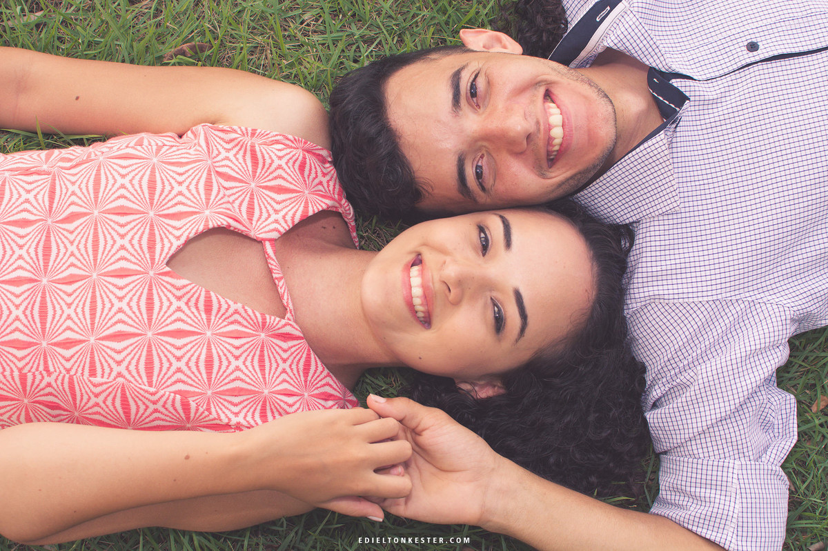 noivos de maos dadas sorrindo pra camera deitados em ensaio pelo fotografo de casamentos ro edielton kester