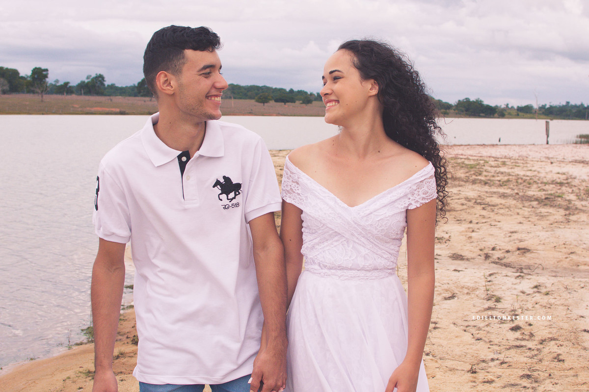 noivos caminhando de maos dadas se olhando na praia