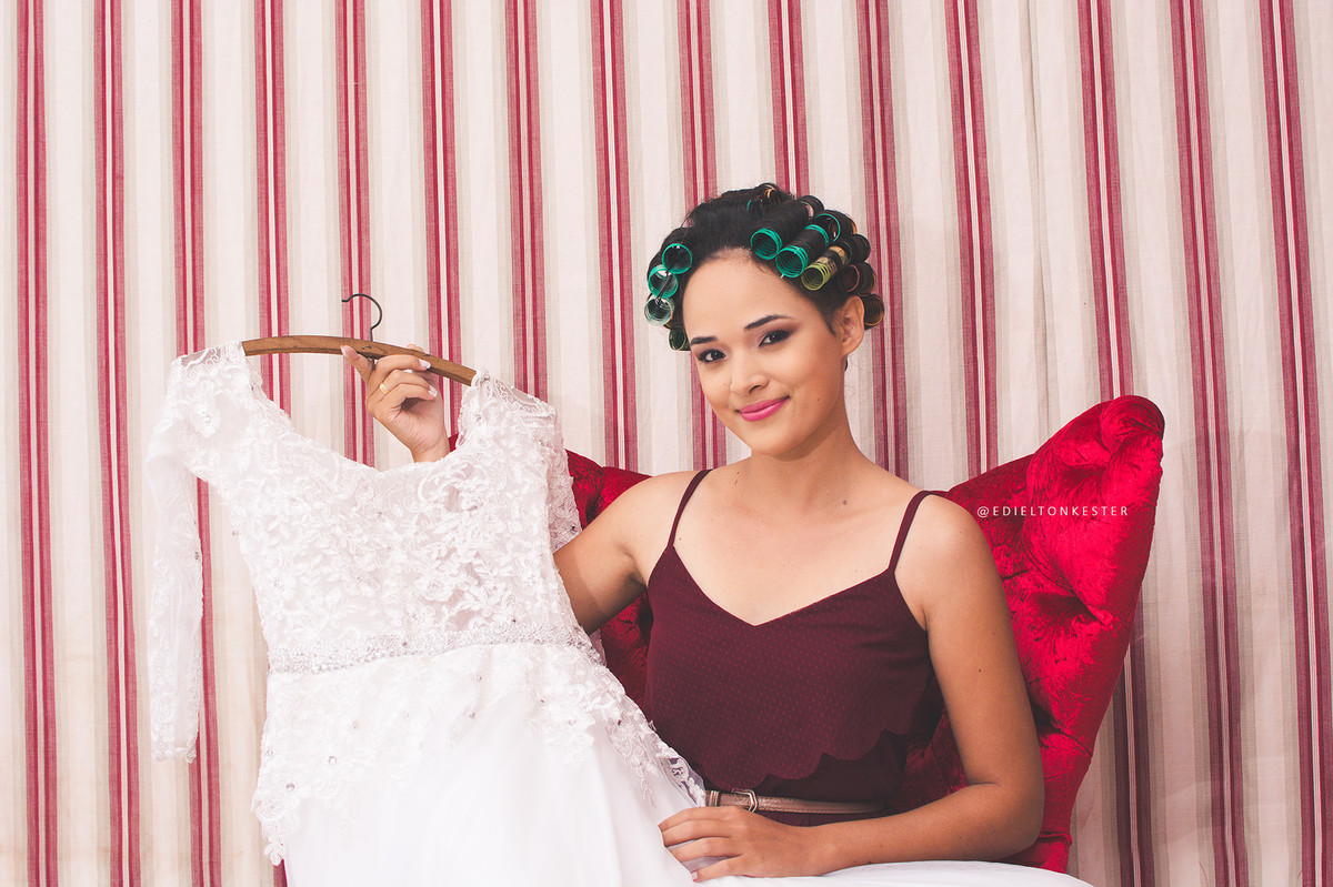 noiva sentada em poltrona segurando o proprio vestido