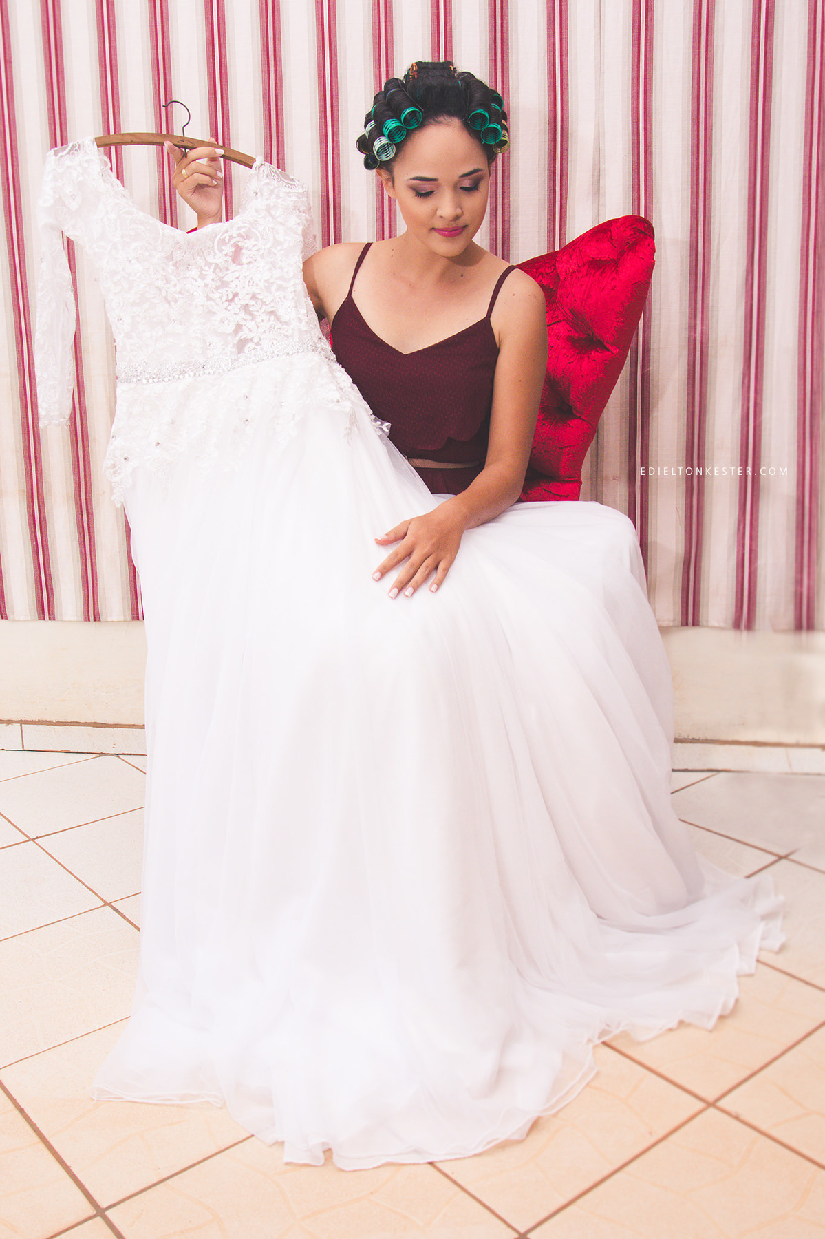 noiva sentada em poltrona segurando o proprio vestido