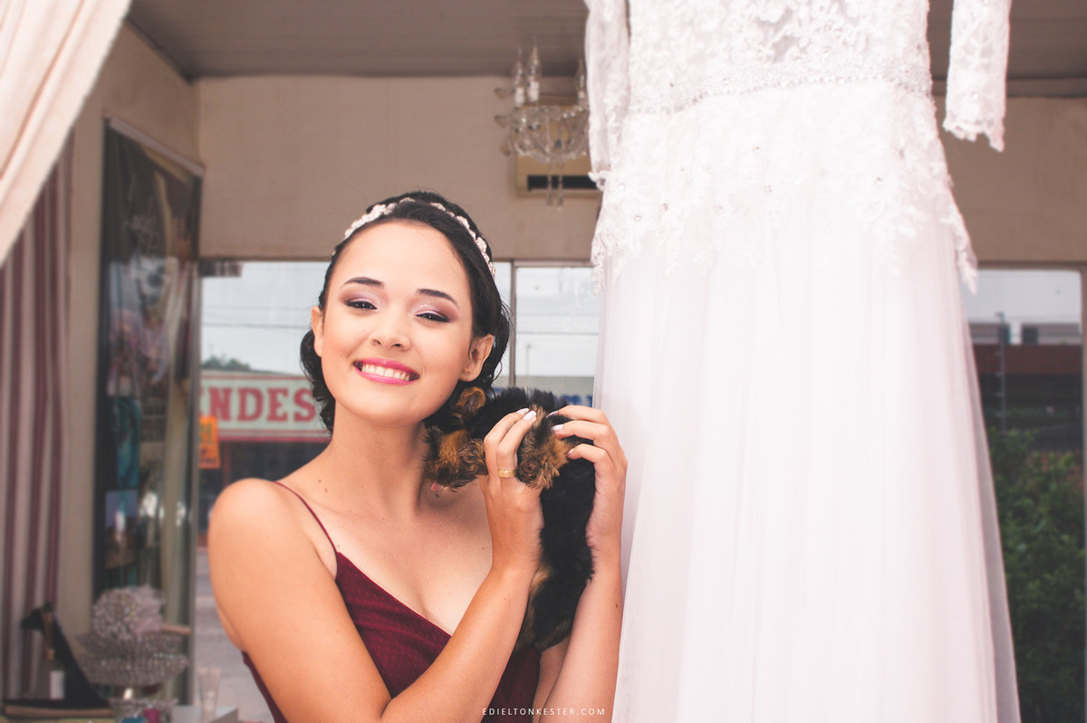 noiva posando para fotos em making of segurando um cachorrinho