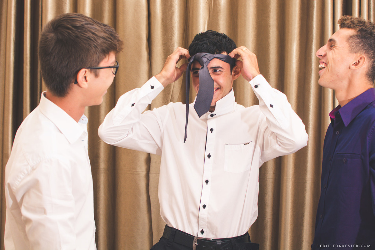 noivo colando a gravata pela cabeça e todo mundo dando risada