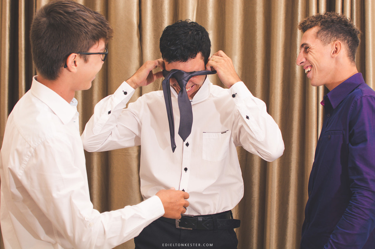 noivo colando a gravata pela cabeça e todo mundo dando risada