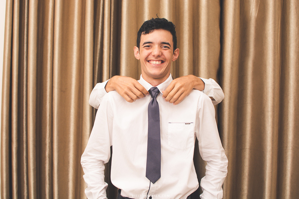 amigo do noivo arrumando sua gravata em pose criativa de making of