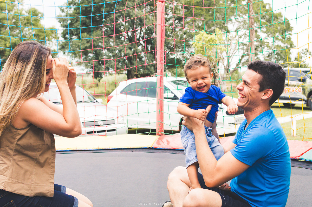 pais brincando com filho sorrindo em aniversário de 1 aninho