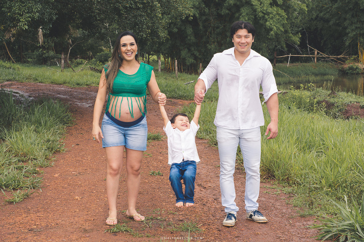 mae gestante e pai brincando com filho