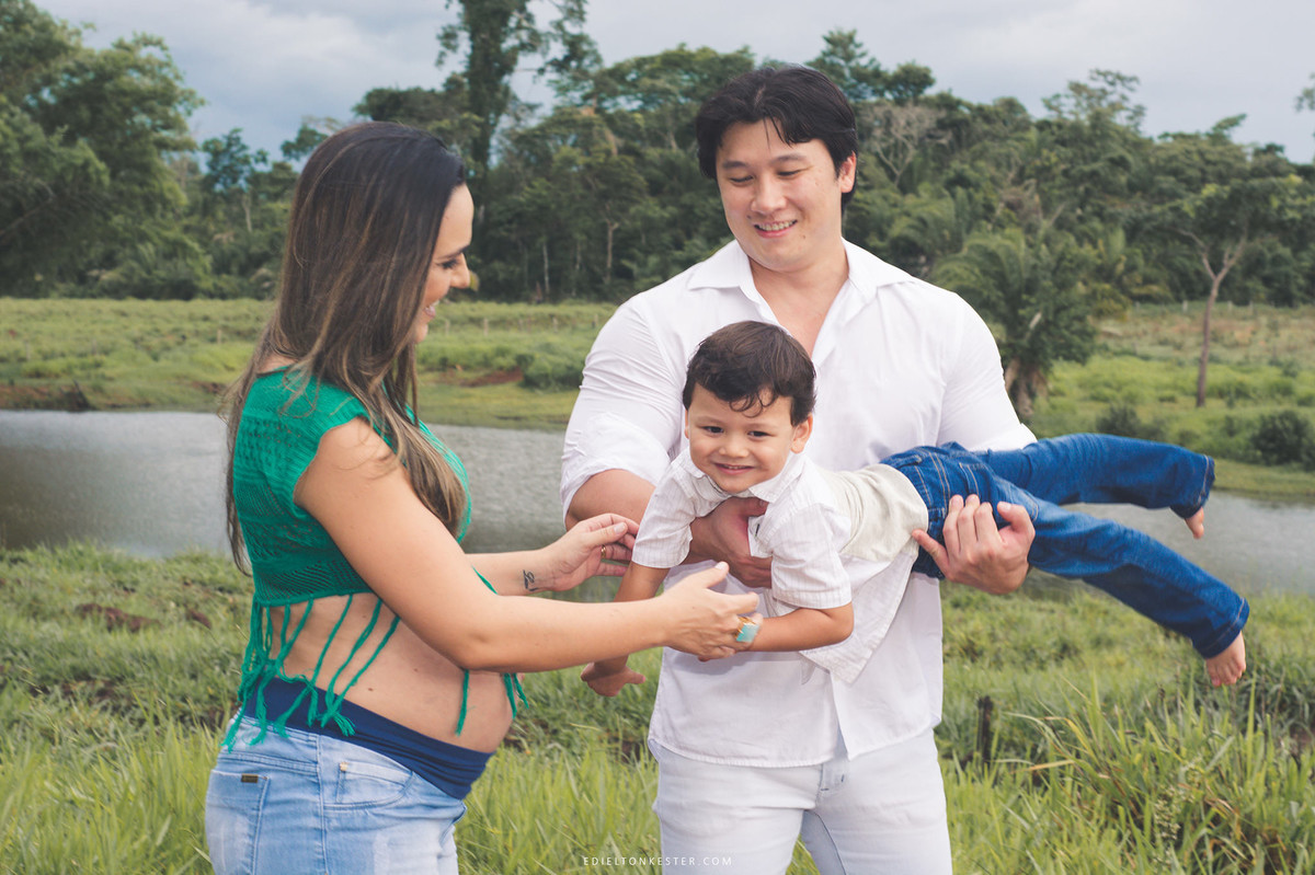 pai e mae brincando com filho em ensaio de gestação