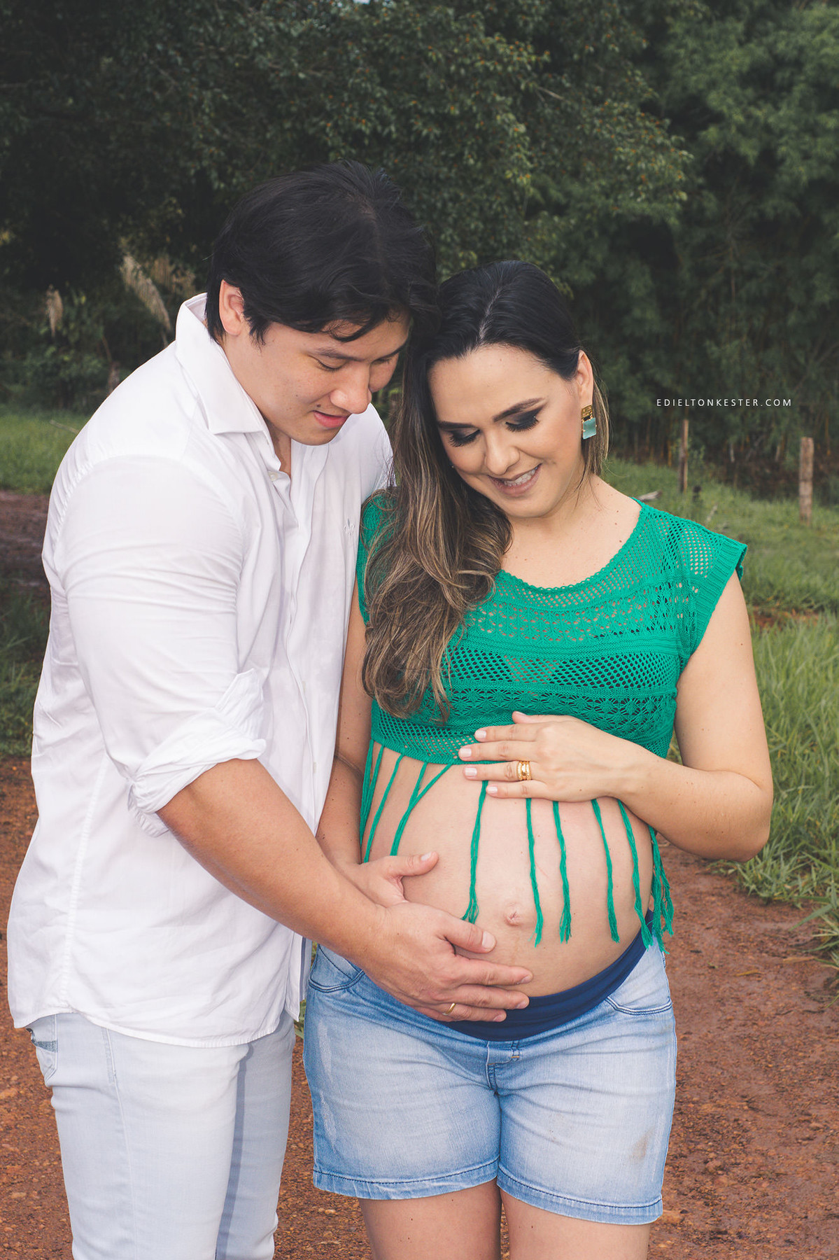 pai e mae com maos na barriga da gestante
