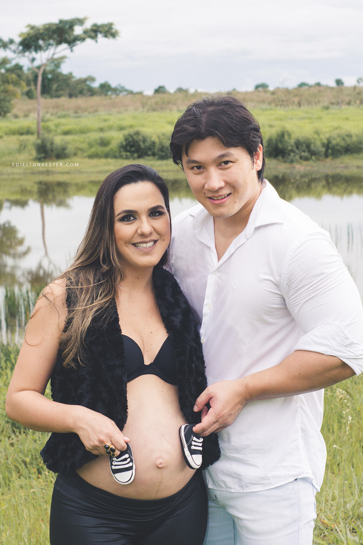 pai e mae com sapatinho na barriga da gestante