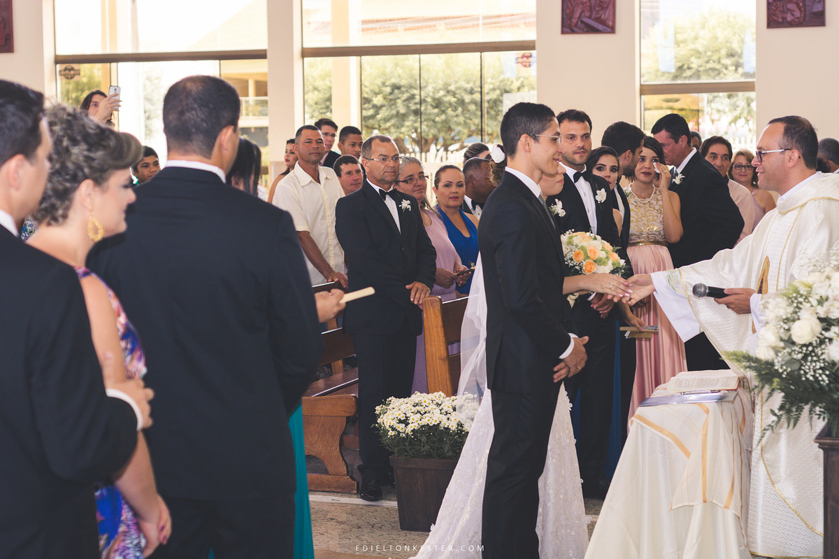 noivos na cerimonia cumprimentando o pastor