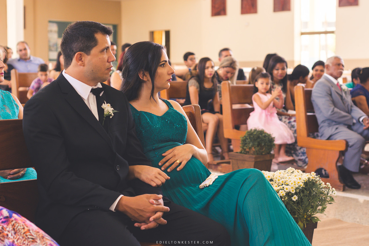 gestante com seu esposo assistindo cerimonia de casamento da irma