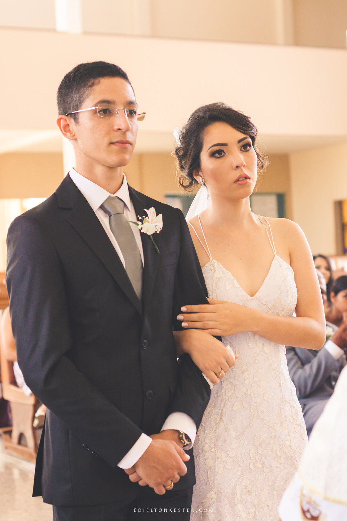 noivos olhando para o frei em moento da cerimonia de casamento de maos dadas