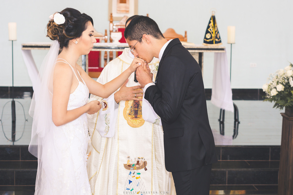 noivo beijando a aliança da noiva