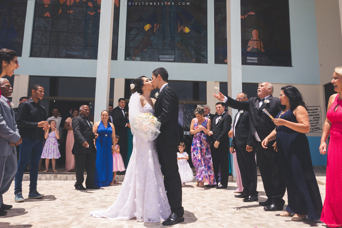 noivos se beijando na frente da igreja apos o casamento