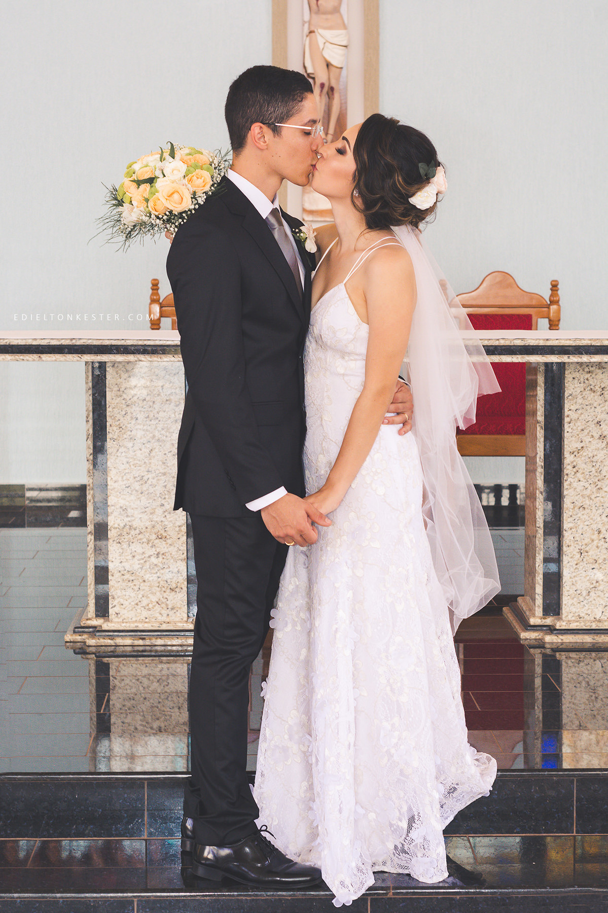 noivos se beijando na igreja e noiva segurando buque
