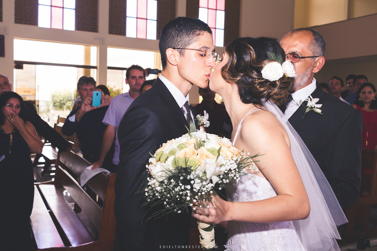 noivos se beijando na entrada